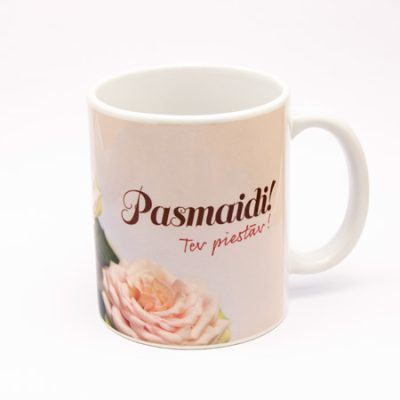 krūze ar gaišu rožu apdruku un tekstu - Pasmaidi!